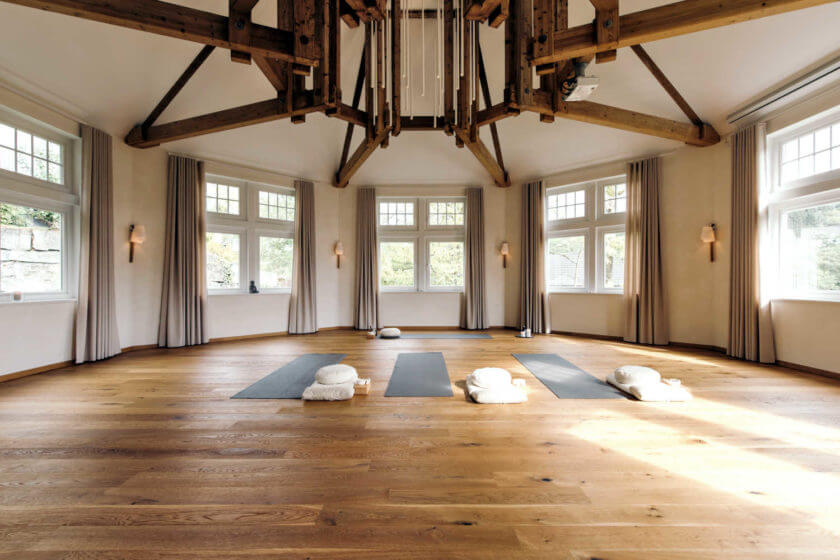 Eine Innenaufnahme vom Haus der Mitte mit drei Yogamatten, Kissen und Decken