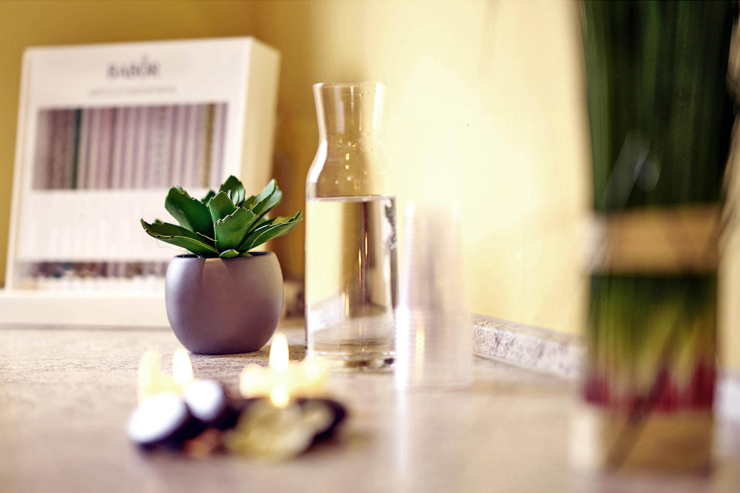 Detailfoto Flasche mit Quellwasser und Wellnessdekoration in der Anwendungskabine