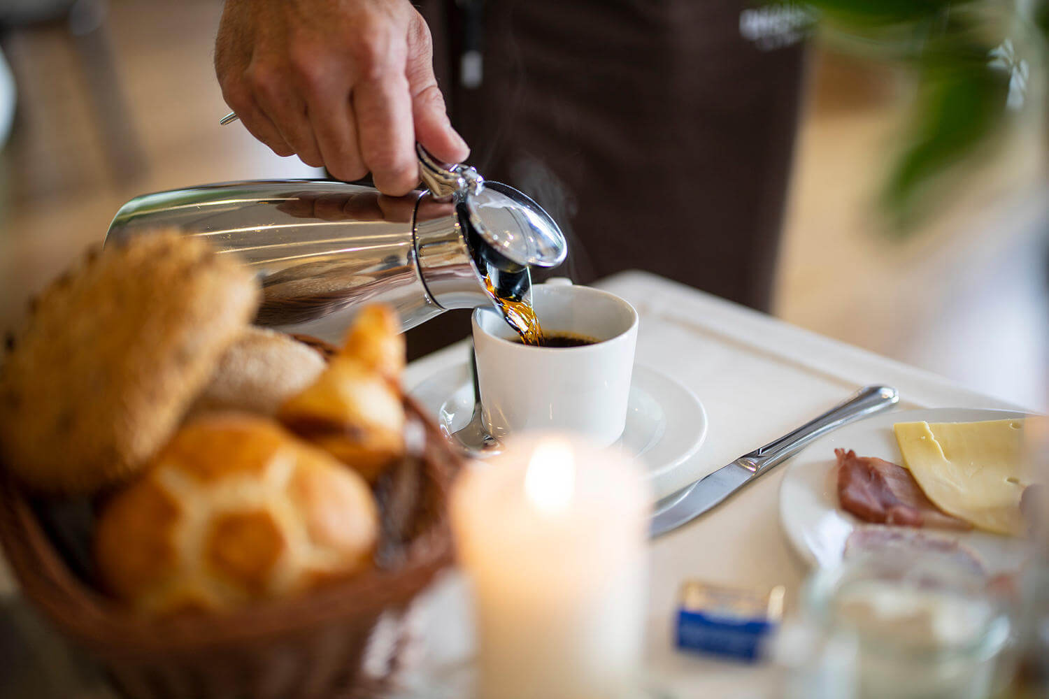 Am Frühstückstisch wird Kaffee aus der Kanne in die Tasse eingeschenkt - Hotel Diedrich