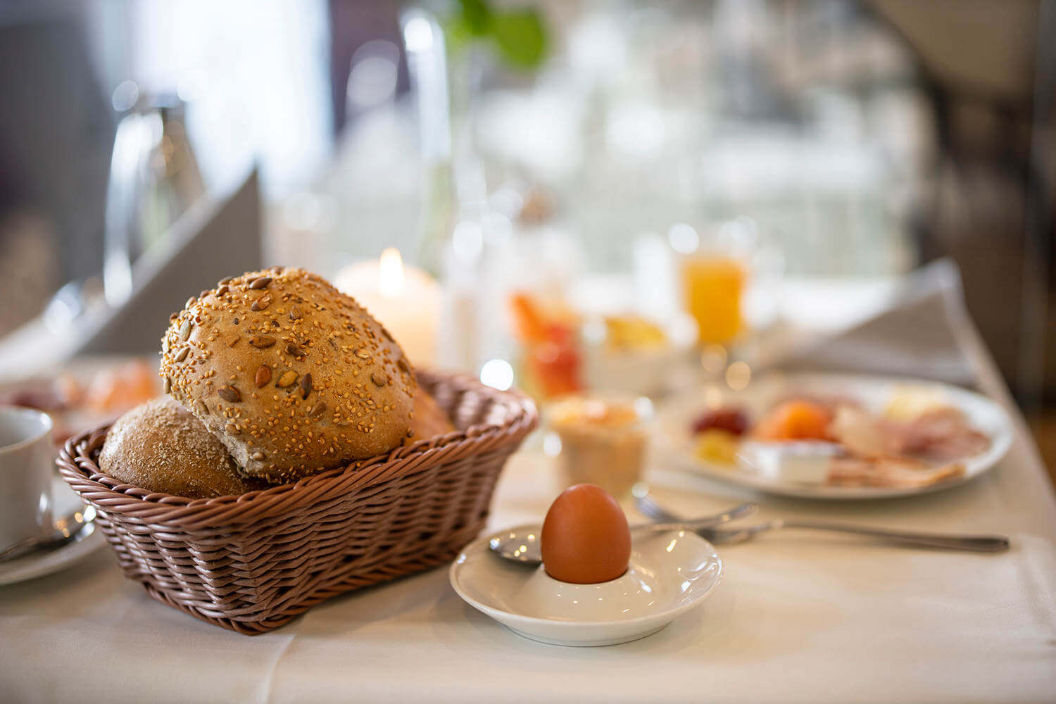 Ein Frühstückstisch mit Brötchen, Ei, und vielem mehr im Hotel Diedrich