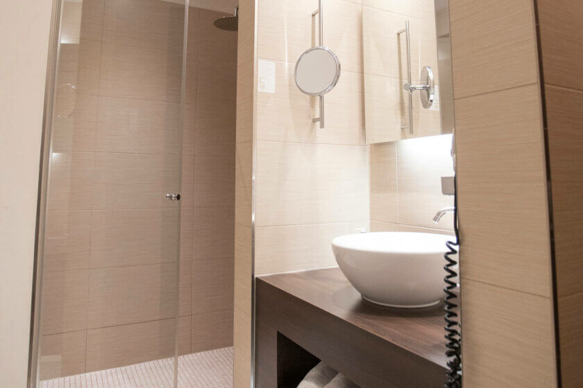 Einblick in das Badezimmer mit verglastem Duschbereich und rundem Waschtisch im Zimmer "Lichtflügel B Straßenseite" im DIEDRICH Wellnesshotel & SPA, Hallenberg in NRW