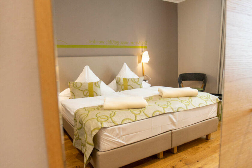Blick auf das Doppelbett im Doppelzimmer der Kategorie "Stammhaus A Talseite" im Wellnesshotel Diedrich im Sauerland