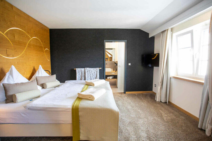 Blick über das Bett in das Badezimmer im Doppelzimmer "Stammhaus Premium Plus Talseite" im DIEDRICH Wellnesshotel & SPA, Sauerland in Nordrhein-Westfalen