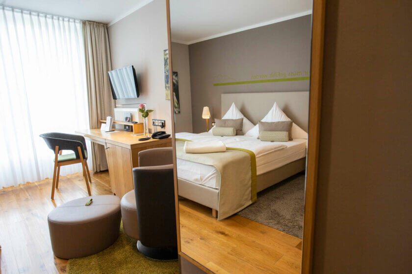 Spiegelblick auf das Bett im Doppelzimmer "Stammhaus Premium Talseite" im Hotel Diedrich, NRW