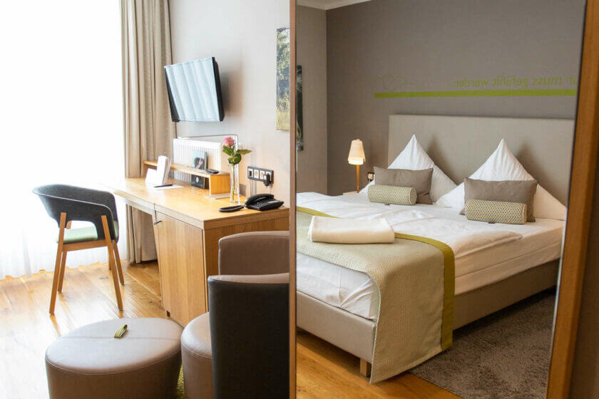 Blick auf Schreibtisch und Spiegel, der das Bett reflektiert; Doppelzimmer "Stammhaus Premium Talseite" im DIEDRICH Wellnesshotel & SPA