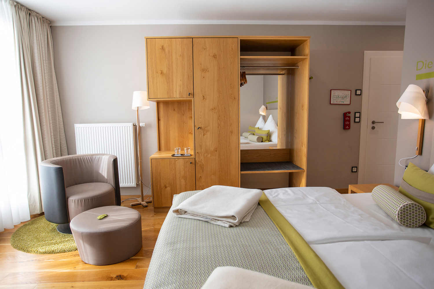 Blick über das Bett auf Sessel und Schrank im Doppelzimmer "Stammhaus Premium Straßenseite" im Hotel Diedrich, Sauerland