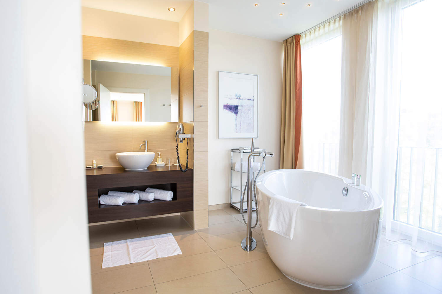 Blick auf Waschtisch und freistehende Badewanne in der "Panorama-Suite 131 Talseite" im DIEDRICH Wellnesshotel & SPA, Hallenberg im Sauerland