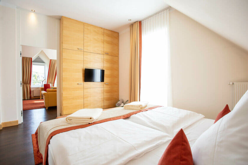 Blick über das Bett bis zum Sitzbereich in der "Panorama-Suite 229 Talseite" im Hotel Diedrich, Sauerland