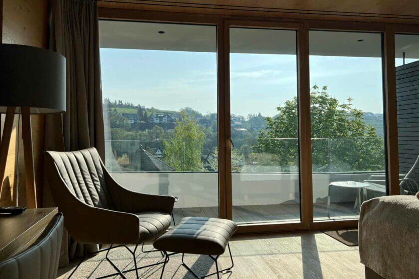 Sonnenstrahlen im Gartenflügelzimmer mit Blick nach draußen auf den Balkon - Hotel Diedrich