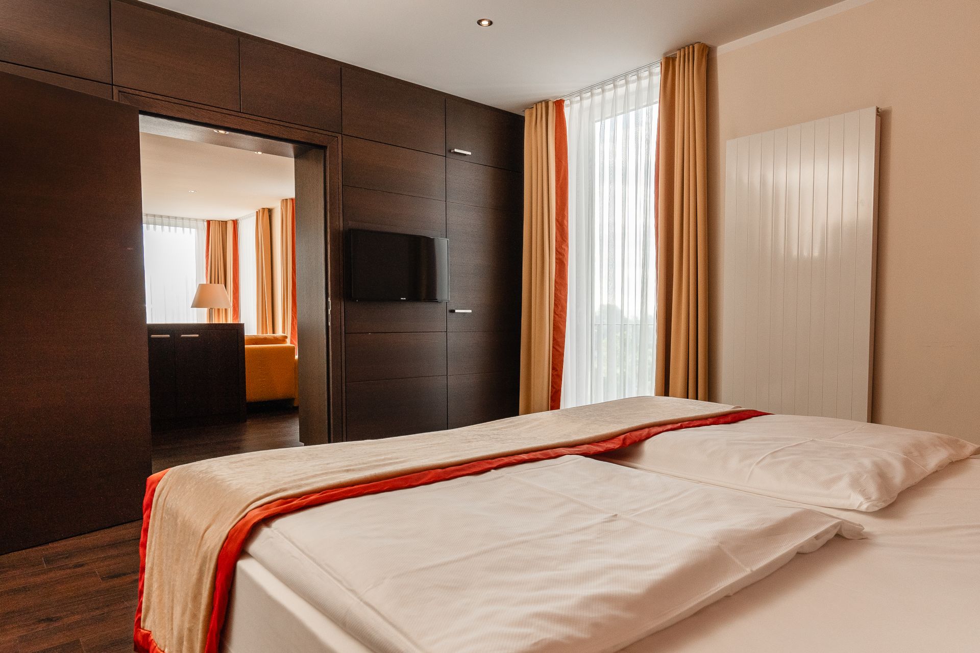 Schlafzimmer der Panoramasuite mit Fernseher und Tür zum Wohnbereich