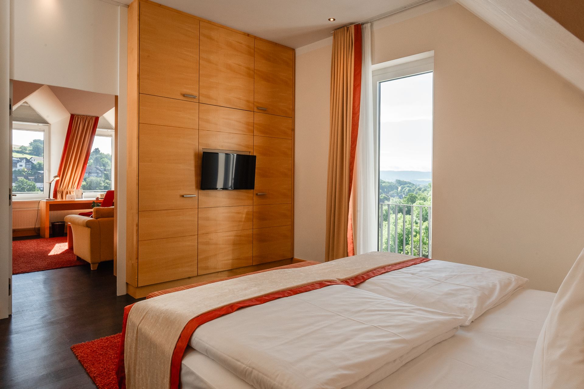 Boxspringbett im Schlafzimmer der Panoramasuite mit Blick ins Grüne
