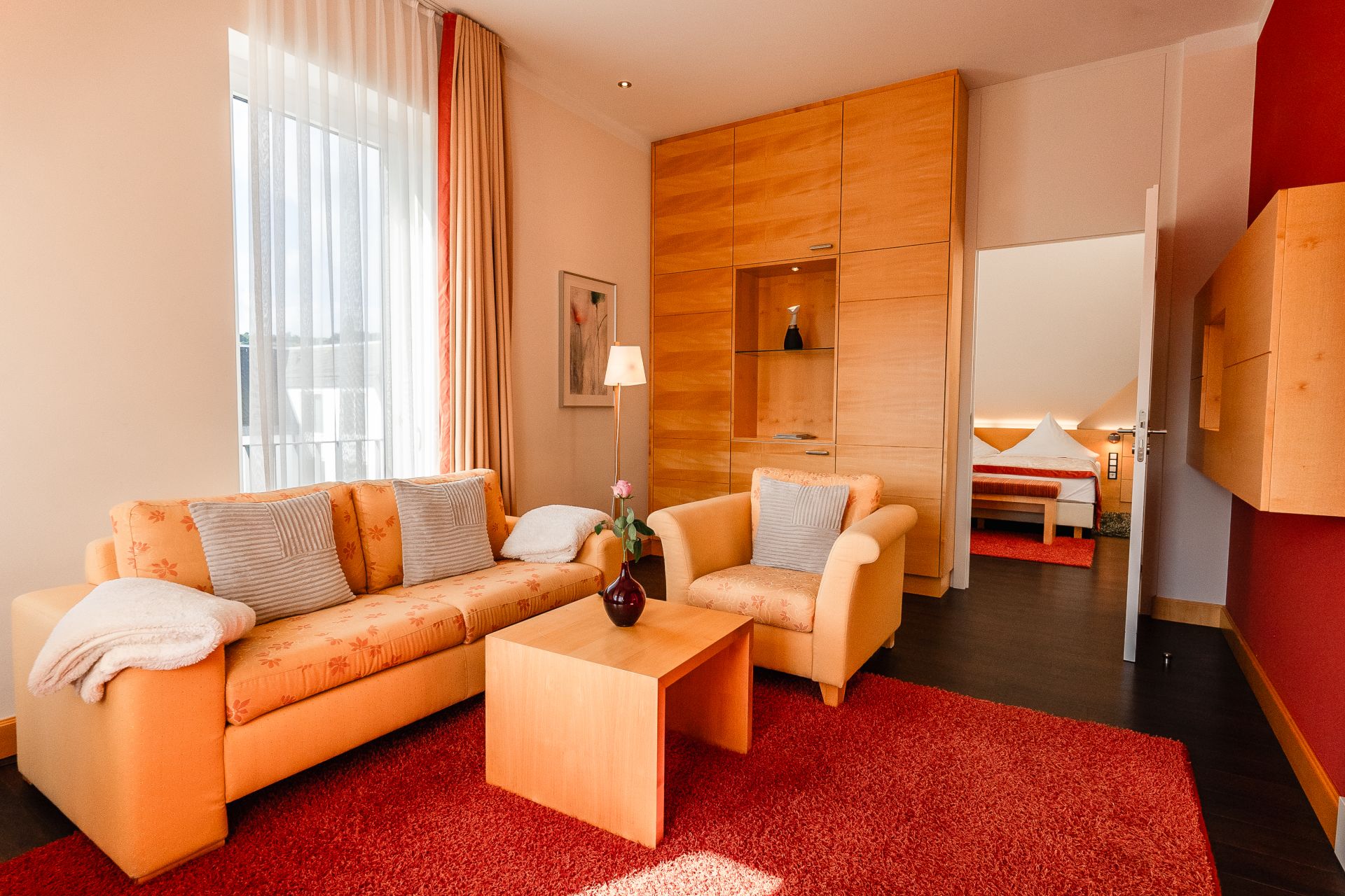 Sofa und Sessel im Wohnbereich der Panoramasuite mit Blick ins Schlafzimmer
